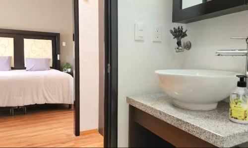 un bagno con lavandino e una camera da letto con un letto di Habitación con baño privado, cerca del Parque Toluca 2000, con áreas comunes compartidas a Santín