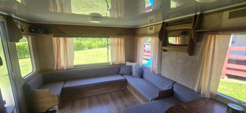an empty train room with two benches and two windows at Domki pod Gruszą in Ełk