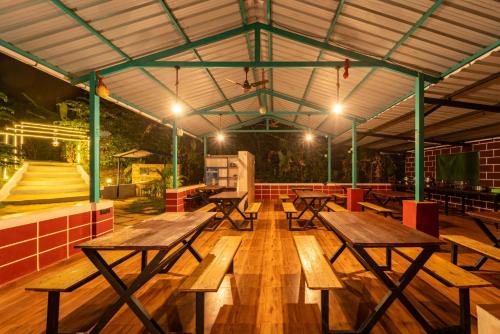 a group of picnic tables in a room with a skate park at white new in Dandeli
