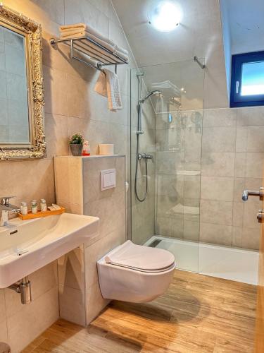 a bathroom with a shower and a toilet and a sink at Etno Garden Apartments in Plitvička Jezera