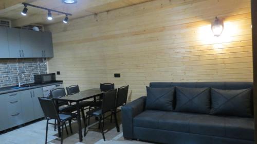 una sala de estar con una mesa y un sofá en Nikolozi, en Kazbegi