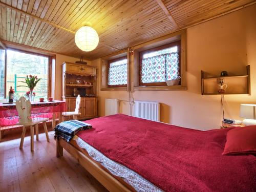 1 dormitorio con 1 cama grande con manta roja en Oremusówka, en Zakopane