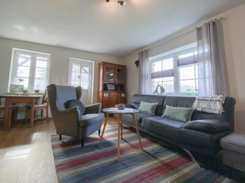 ein Wohnzimmer mit einer Couch und zwei Sesseln in der Unterkunft Appartement Huus Appelboom in Nordstrand