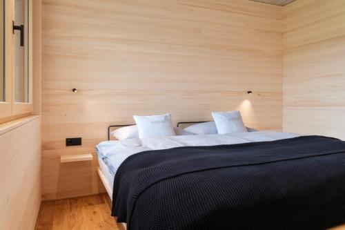 a bedroom with a large bed with white sheets at HEUBERG 1014 - FERIEN - Wohnen in Schwarzenberg im Bregenzerwald