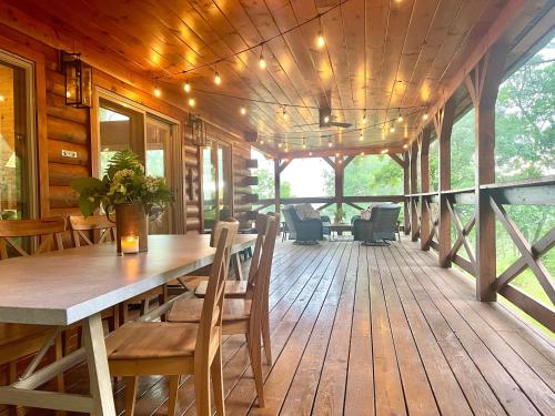 a large wooden deck with a table and chairs at Mossy Falls Cabin by Leavetown Vacations in Altamont