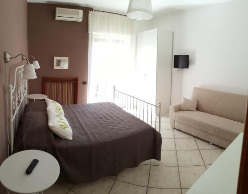 a bedroom with a bed and a couch at B&B Aminei Metrò in Naples