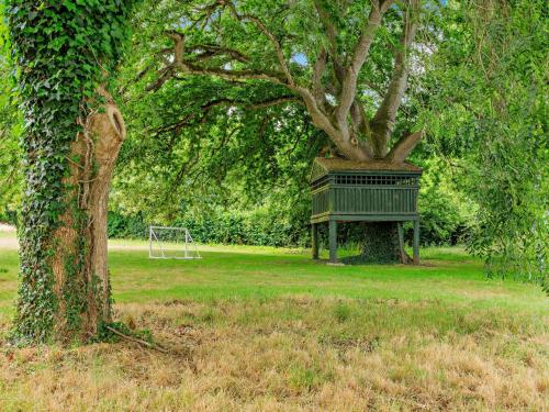 a green park bench sitting next to a tree at 2 Bed in West Quantoxhead 96234 in West Quantoxhead