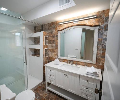 a bathroom with a sink and a shower and a mirror at Wellness Sanctuary min to NYC Sleeps 9 w Garage in West New York