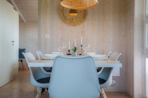 a dining room with a white table and white chairs at Ferienhaus Huus Eiderwatt ID 460 in Wesselburenerkoog
