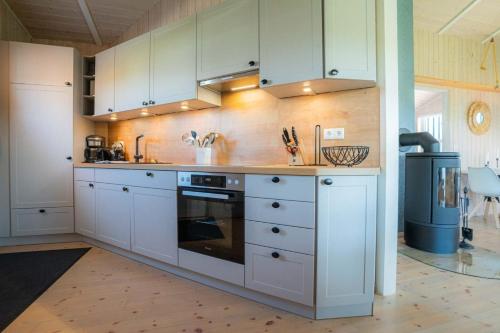 a kitchen with white cabinets and a stove at Ferienhaus Huus Eiderwatt ID 460 in Wesselburenerkoog