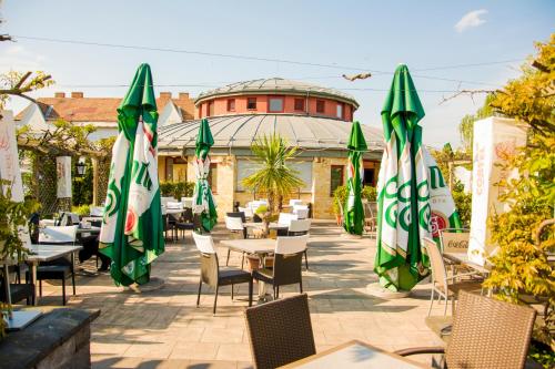 een restaurant met tafels en stoelen met parasols bij Corner Motel in Zalaegerszeg