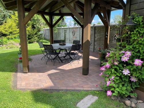 a patio with a table and chairs and flowers at Ferienhaus Blütenzauber in Stennewitz