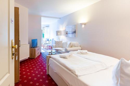 a bedroom with a bed and a living room at Strandhaus Claassen 02 in Ahrenshoop