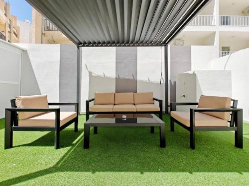 two chairs and a coffee table on some grass at Blossom in Marsaskala