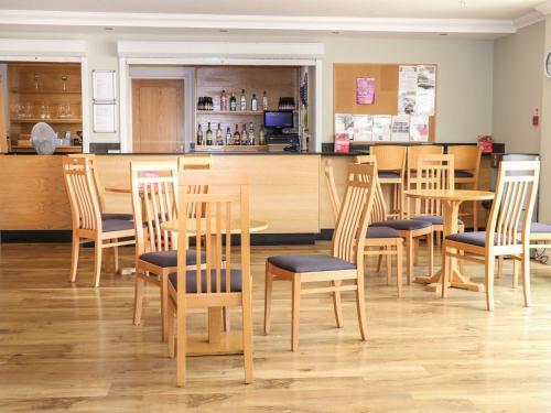 a restaurant with wooden tables and chairs and a counter at Seashell Suite at Marine Court in Littlehampton