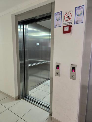 a elevator with a glass door in a building at Encantador Departamento excelente conectividad al centro y principales Rutas in Rancagua