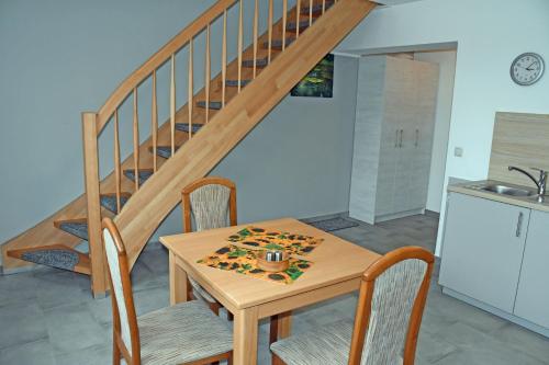 a table and chairs in a kitchen with a staircase at Ferienwohnungen Udars auf Rügen in Udars