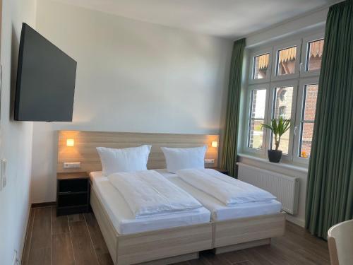 a bedroom with a large white bed and a window at Lokschuppen Pasewalk- Gästehaus Lokschuppen in Pasewalk