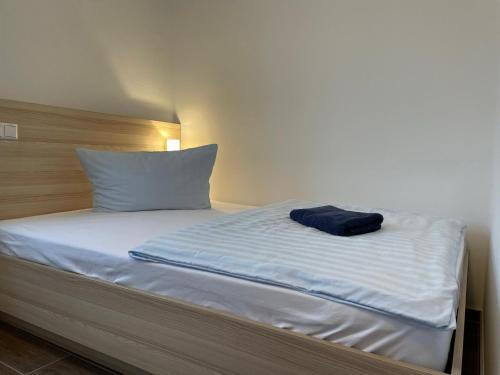 a bed with a blue towel on top of it at Lokschuppen Pasewalk- Gästehaus Lokschuppen in Pasewalk
