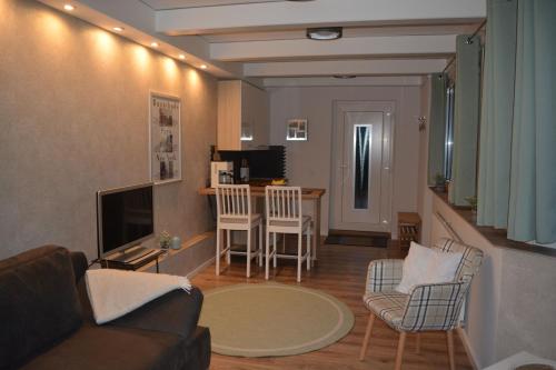 a living room with a couch and chairs and a television at Kiek mol in in Ottensen