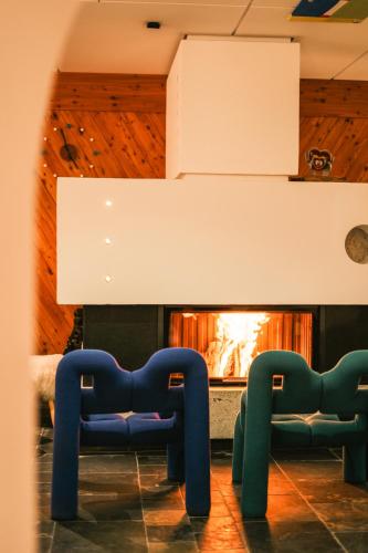 two blue chairs in front of a fireplace at Hotel Glemmtalerhof in Saalbach Hinterglemm