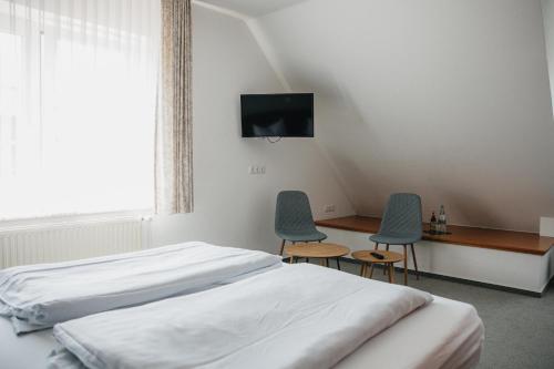 a bedroom with a bed and two chairs and a desk at HofZeit in Walsrode