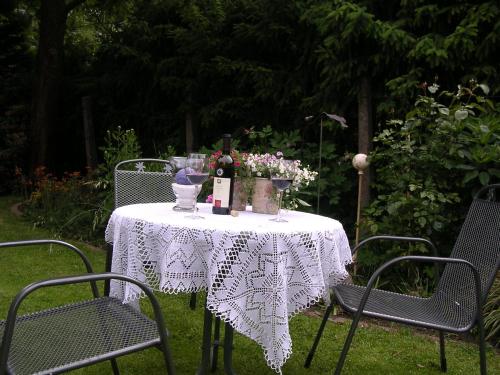 a table with a white table cloth and flowers on it at Landgasthaus Zum Naturschutzpark in Bispingen