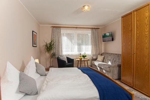 a bedroom with a large bed and a living room at Landgasthaus Zum Naturschutzpark in Bispingen