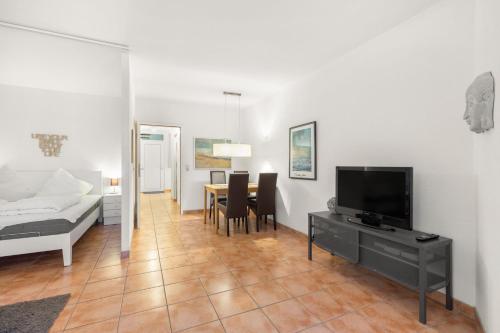 Una sala de estar con una cama, un televisor y una mesa. en Grömitz-Center Whg 209, en Grömitz