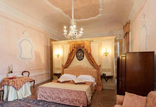a bedroom with a bed and a chandelier at CastelBrando in Cison di Valmarino
