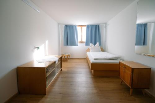 a small room with two beds and a desk at Haus Berchtold am Hüttersberg in Doren