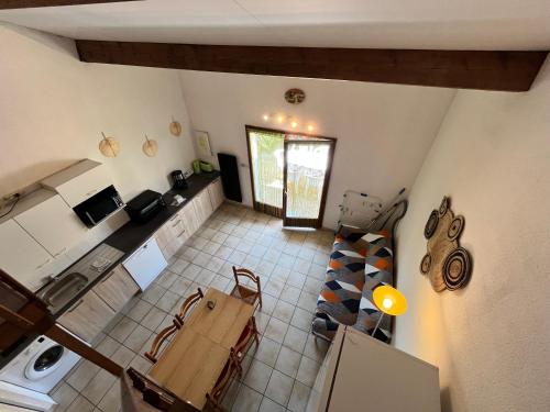 d'une cuisine avec une table. dans l'établissement Belle villa 5 couchages terrasse parking dans résidence sécurisée piscine commune 400m de la mer LRJP16, à Portiragnes