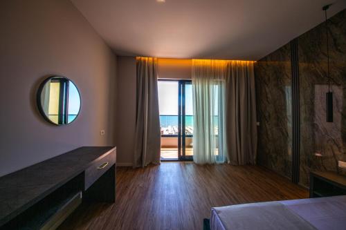 a bedroom with a large window with a view of the ocean at New Benilva Hotel in Durrës