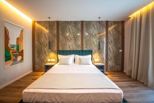 a bedroom with a large bed with two night stands at New Benilva Hotel in Durrës