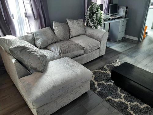 a living room with a couch and a table at Newly renovated & furnished luxury bedroom in Kirkliston