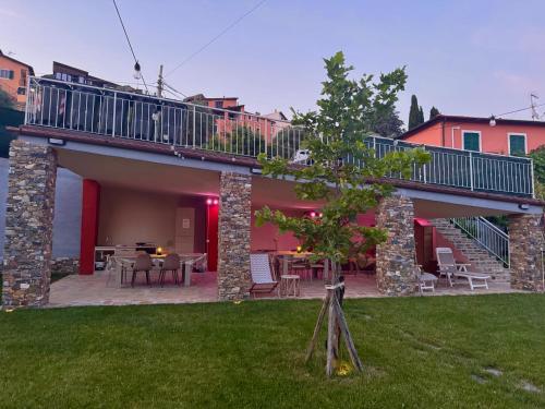 a house with a deck and a yard with grass at Ligo in Villanova dʼAlbenga