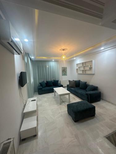 a living room with two blue couches and a table at Coquette appart de plage in Hammam Sousse
