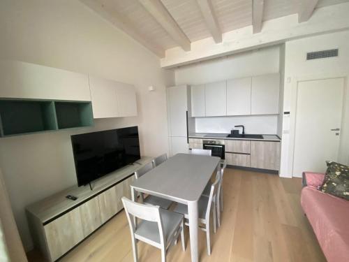 a kitchen and living room with a table and a couch at Wave Island in Lido di Jesolo