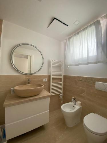 a bathroom with a sink and a toilet and a mirror at Wave Island in Lido di Jesolo