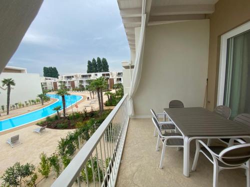 a balcony with a table and chairs and a pool at Wave Island in Lido di Jesolo