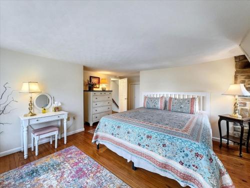una camera da letto con un letto, un tavolo e uno specchio di The White House by Leavetown Vacations a Wrightsville