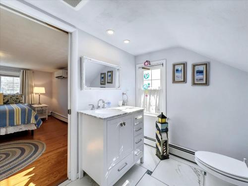 un bagno bianco con lavandino e una camera da letto di The White House by Leavetown Vacations a Wrightsville