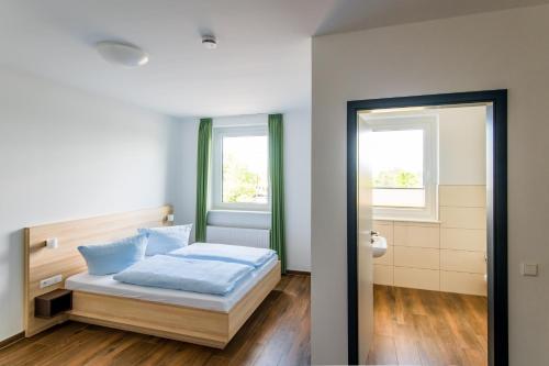 a bedroom with a bed and two windows at Lokschuppen Pasewalk- Gästehaus Lokschuppen in Pasewalk