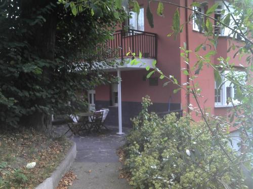 un edificio rojo con balcón y mesa en Apartamentos Los Balcones, en Tineo