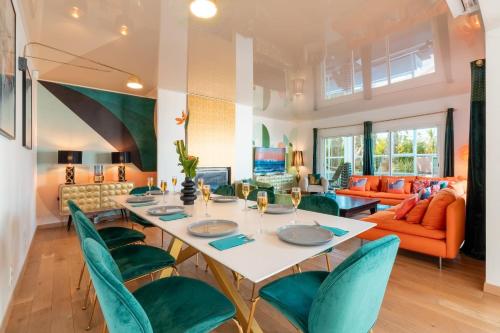 Una sala de estar con una mesa y sillas verdes. en Villa Summer Wind, en Le Grau d'Agde