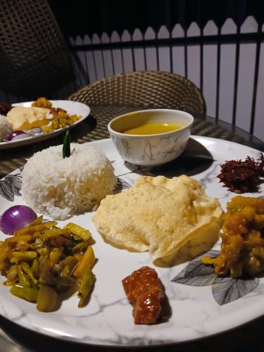 a plate of food with rice and a bowl of soup at The Gulmohar Inn in Guwahati