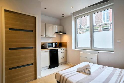 Il comprend une petite cuisine avec un lit et une fenêtre. dans l'établissement Charmant studio proche de la Gare Lille Flandres, à Lille