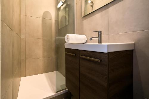 une salle de bain avec un lavabo et un miroir dans l'établissement Charmant studio proche de la Gare Lille Flandres, à Lille