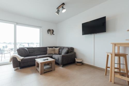 a living room with a couch and a flat screen tv at Exklusive Ferienwohnungen an der Havel in Werder