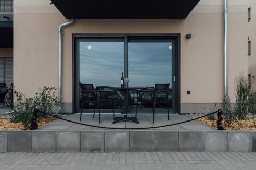 a patio with a table and chairs in front of a building at Exklusive Ferienwohnungen an der Havel in Werder